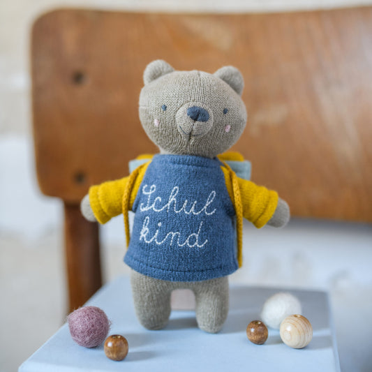 Bär „Schulkind“ mit Schulranzen und Shirt in blau/gelb Kuscheltier